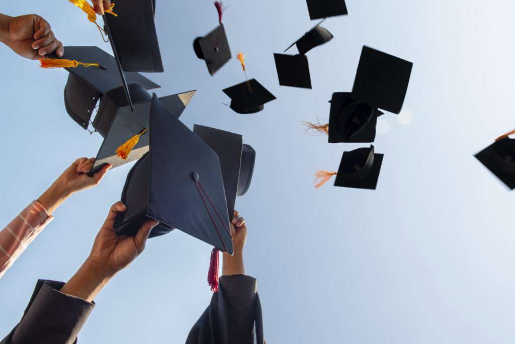 Black hats of the graduates floating in the sky.